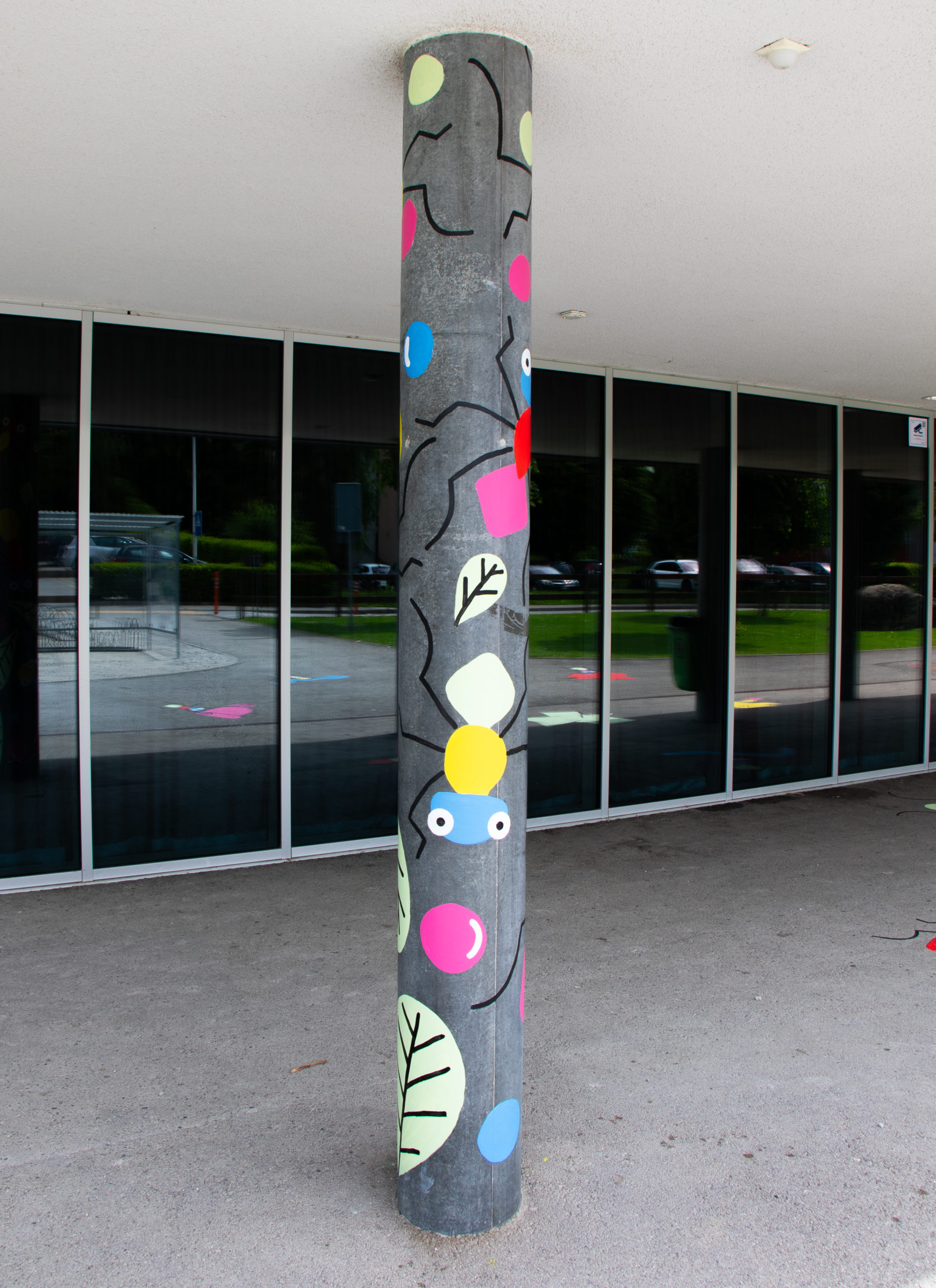 Poteau dans la cour de l'école de Hauterive où on voit des fourmis qui ont été peintes pour la fresque